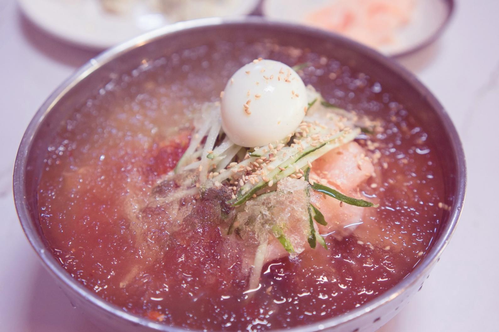 包丁で野菜を切る様子と調理台に並んだ新鮮な食材